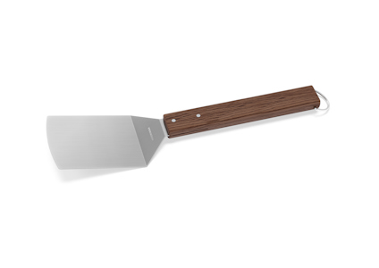 Stekspade med metallblad och trähandtag, samt en metallögla för upphängning.