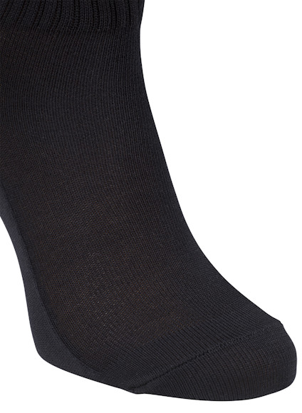 En svart strumpa täcker underbenet och foten.