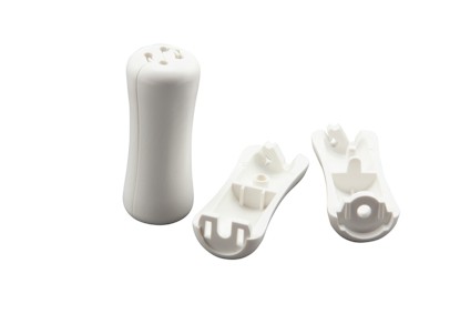Vita plastdelar, en stående cylinder och två sidodelar, alla med utskärningar och fästen.