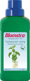 Grön flaska med etikett där det står "Blomstra", "Hydroponisk näring" och en bild på en växt med rötter i vatten.