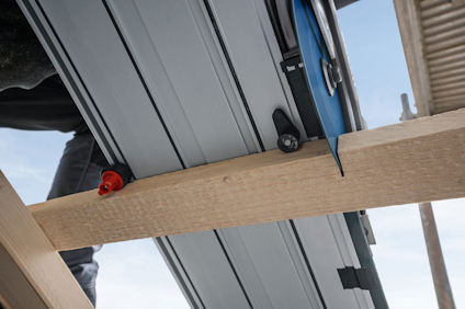 Takpanel i metall monterad på trästomme under byggnadskonstruktion.