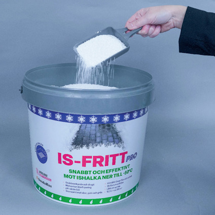 Hink med etikett "IS-FRITT Pro" och text om smältande snö och is. Hand häller vitt granulat från en spade.